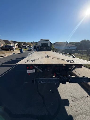 Flatbed tow truck on suburban street, view from truck bed