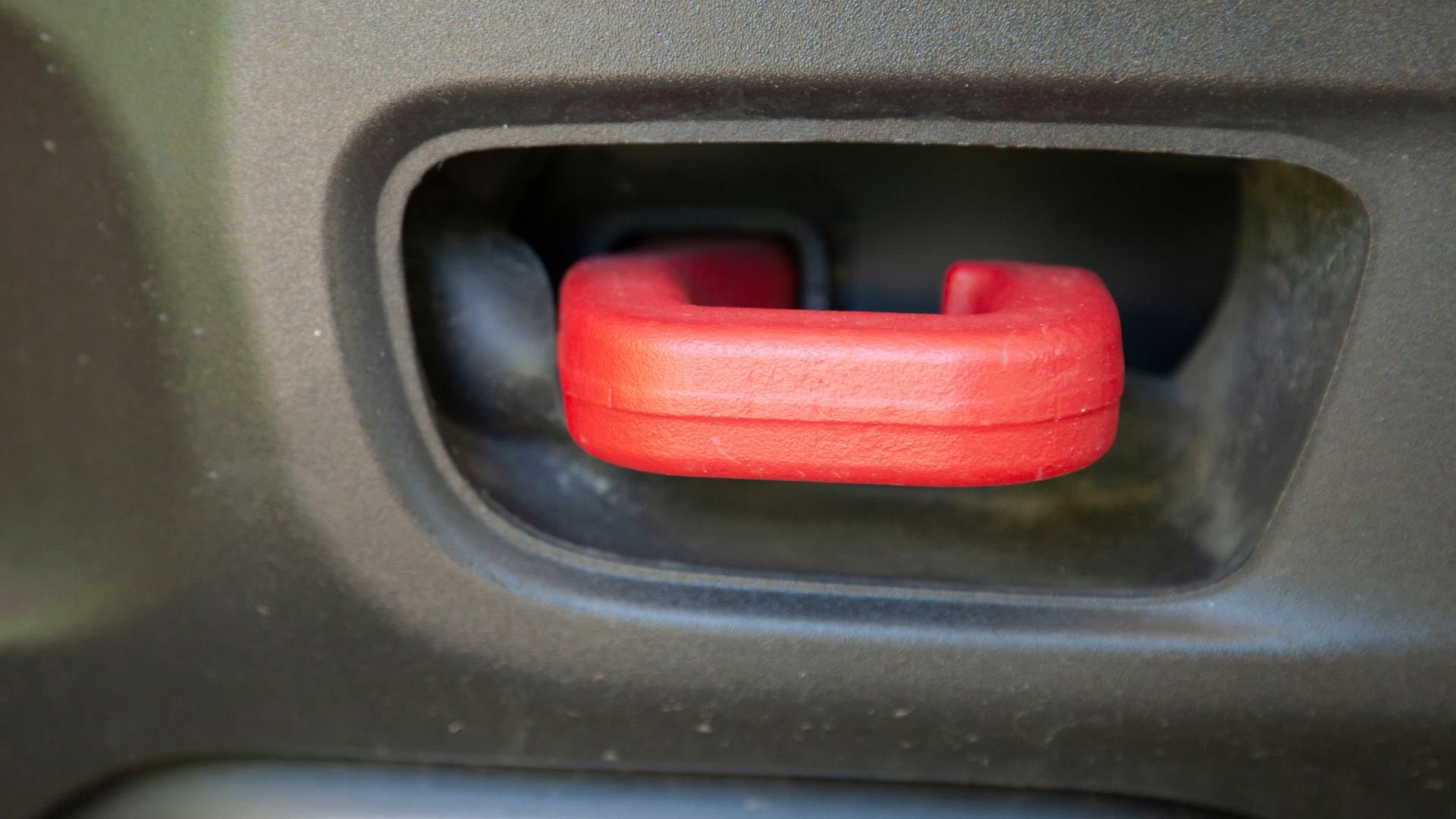 Bright red safety button or latch inside vehicle compartment